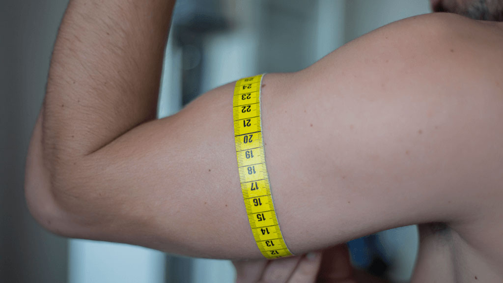 Personne mesurant son avant-bras avec un mètre ruban souple